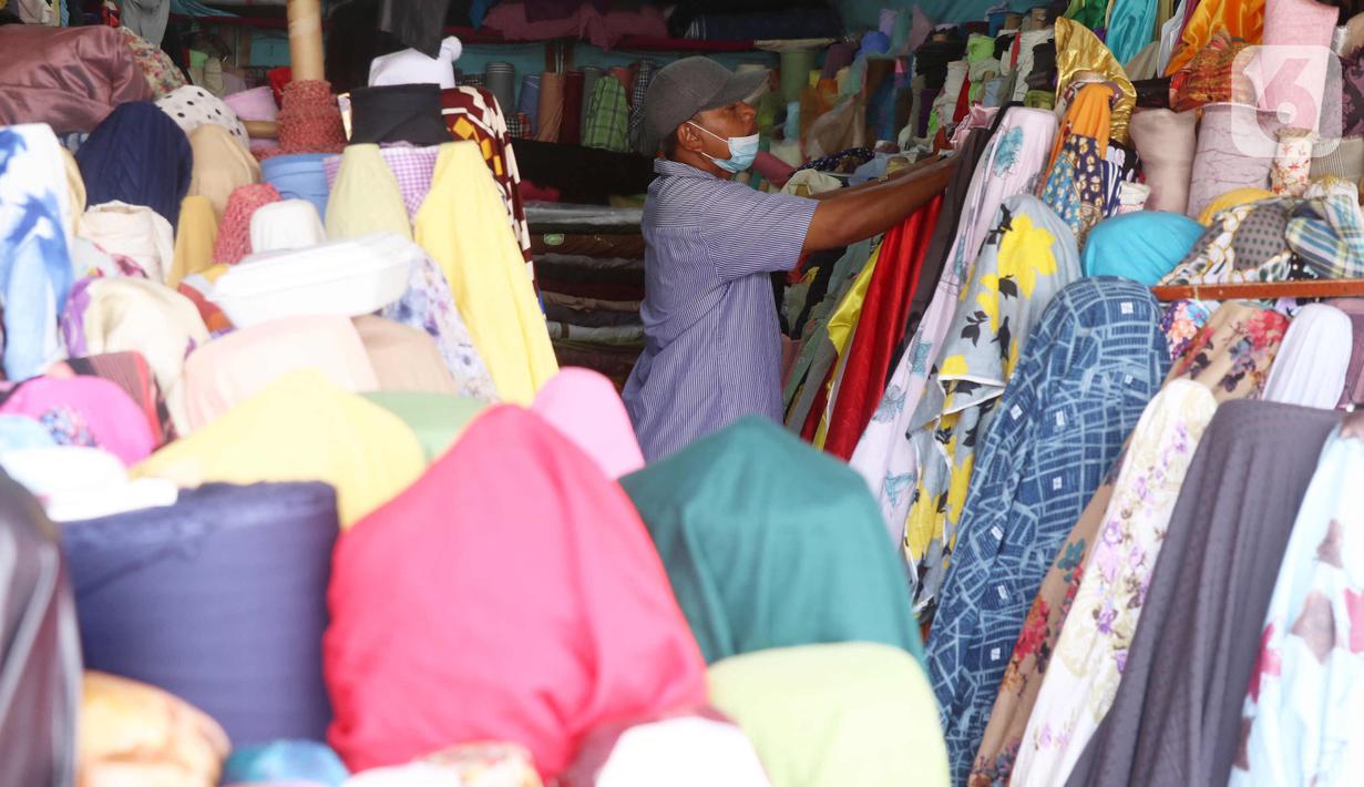 Pedagang menata kain dagangan di Pasar Cipadu, Tangerang, Selasa (2/3/2021). Pandemi Covid-19 membuat industri tekstil dan pakaian jadi mengalami pertumbuhan negatif 8, 8% sepanjang 2020, bahkan pandemi membuat tenaga kerja di sektor industri tekstil berkurang hingga 13%. (Liputan6.com/Angga Yuniar)