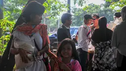 Seorang anak tersenyum usai ibunya berhasil membeli beras saat operasi pasar beras oleh BULOG di Lenteng Agung, Jakarta, Senin (2/3/2015). Operasi ini digelar sebagai upaya menurunkan harga beras yang terus naik.(Liputan6.com/Yoppy Renato)