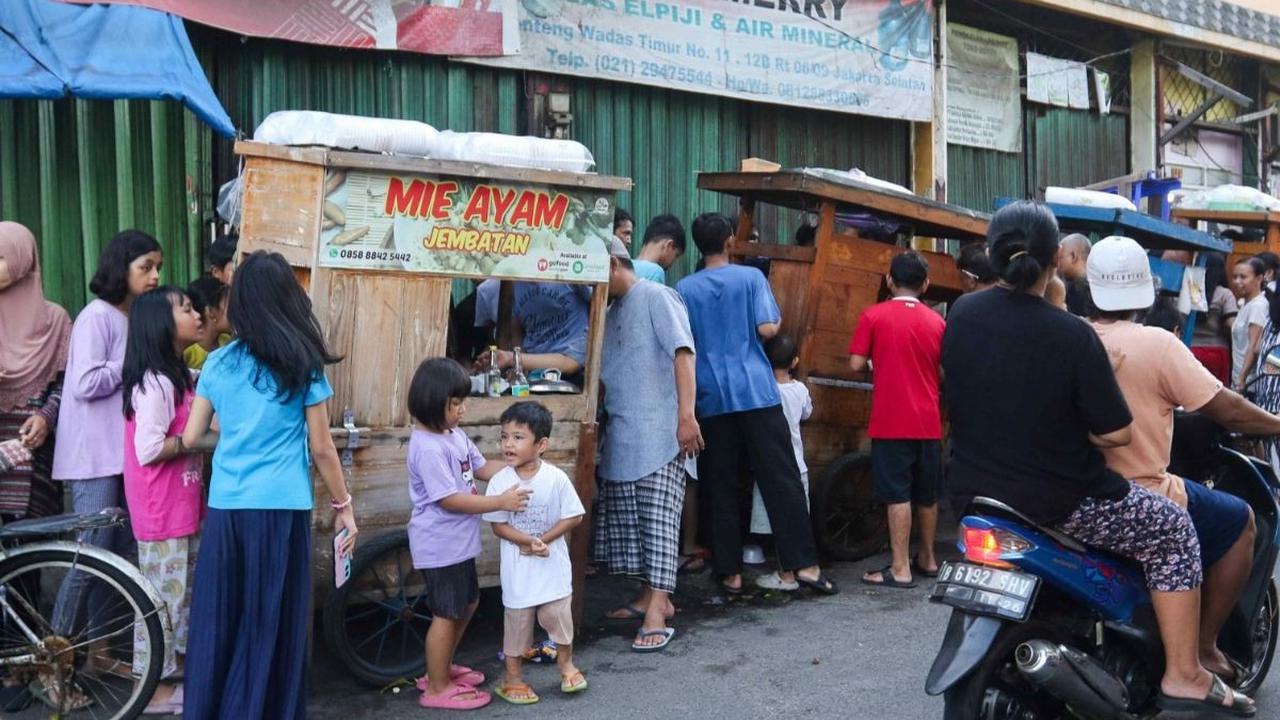 Relawan Jokowi membagikan susu dan mie ayam gratis kepada warga yang melintas di wilayah Menteng Wadas Timur, Jakarta, Selasa (30/4/2024). Foto: Liputan6.com / Herman Zakharia