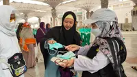 Petugas haji membagikan masker kepada jemaah di halaman Masjid Nabawi, Madinah. Pemerintah mengimbau para jemaah haji Indonesia mewaspadai penularan MERS-CoV. (Foto: MCH PPIH 2023)