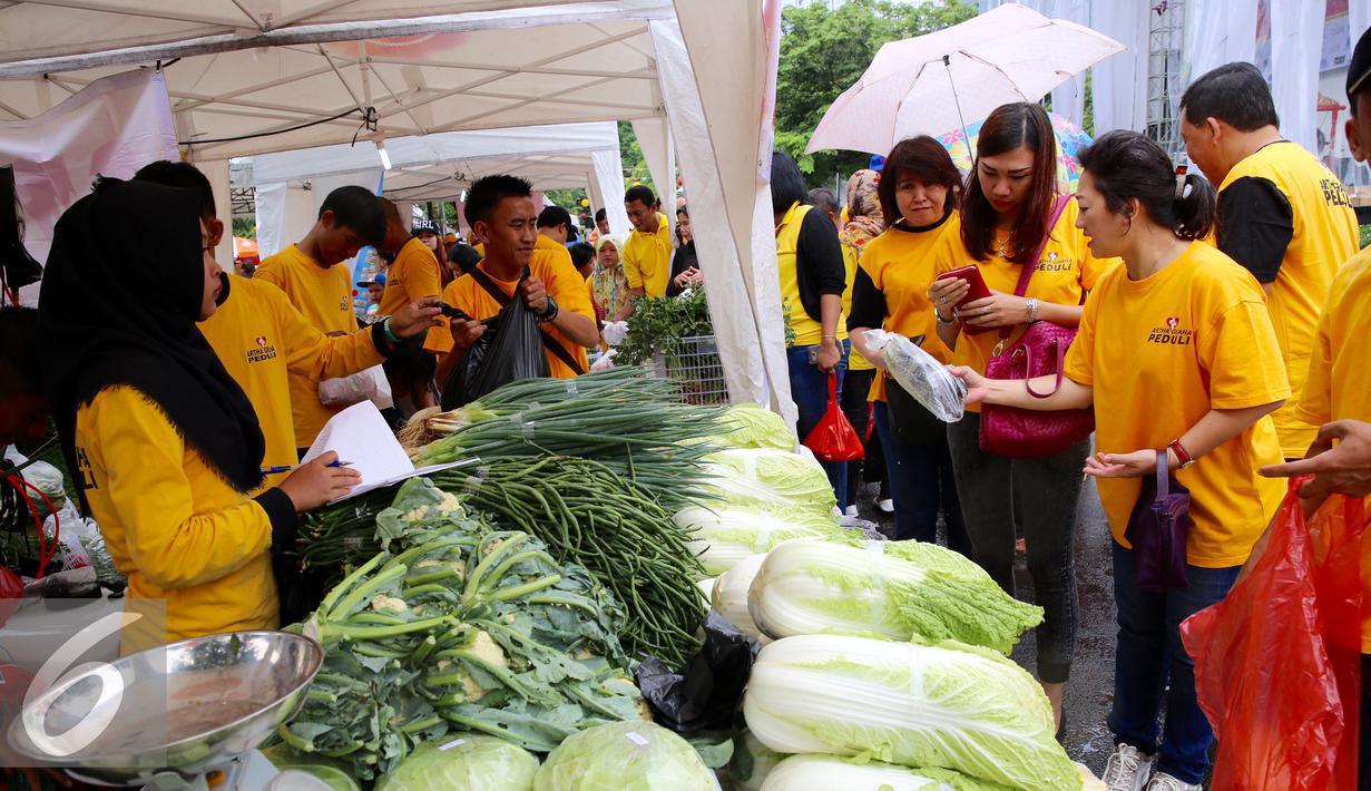 Pedagang melayani pembeli di stand sayur mayur pada acara kick off pasar murah di Kawasan SCBD, Jakarta (14/1). Kegiatan ini membantu masyarkat Indonesia yang kurang beruntung. (Liputan6.com/Fery Pradolo)