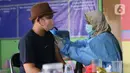 Petugas kesehatan menyuntikkan vaksin covid-19 kepada warga di kawasan Tanah Tinggi, Kota Tangerang, Jumat (4/3/2022). Pemkot Tangerang mengadakan operasi pasar minyak dan daging murah bagi warga yang melaksanakan vaksinasi covid-19 di lokasi. (Liputan6.com/Angga Yuniar)