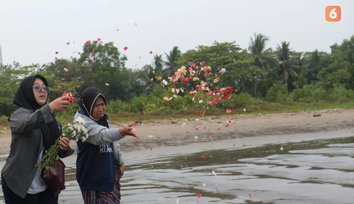 Keluarga menaburkan bunga ke laut dalam prosesi untuk lima jurnalis dan tiga kru kapal Arupadhatu 1 di pantai dekat Dermaga Pegedongan, Banten, Jumat (18/9/2026). Dermaga tersebut menjadi titik awal keberangkatan delapan orang itu pada Senin (7/9/2026). (KLY/Budy Santoso)