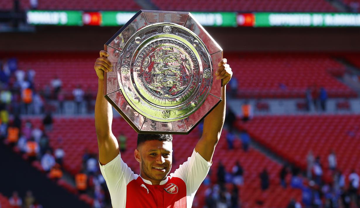 Pencetak gol kemenangan Arsenal atas Chelsea, Alex Oxlade-Chamberlain dengan trofi Community Shield 2015 di Stadion Wembley, Inggris. Minggu (2/8/2015) malam WIB. (Reuters/Darren Staples)