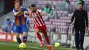 Pelatih Atletico Madrid, Diego Simeone (kanan)  menyaksikan pemainnya Yannick Carrasco memperebutkan bola dengan gelandang Barcelona, Frenkie de Jong selama pertandingan lanjutan La Liga Spanyol di stadion Camp Nou di Barcelona, Spanyol, Sabtu (8/5/2021). (AP Photo / Joan Monfort)