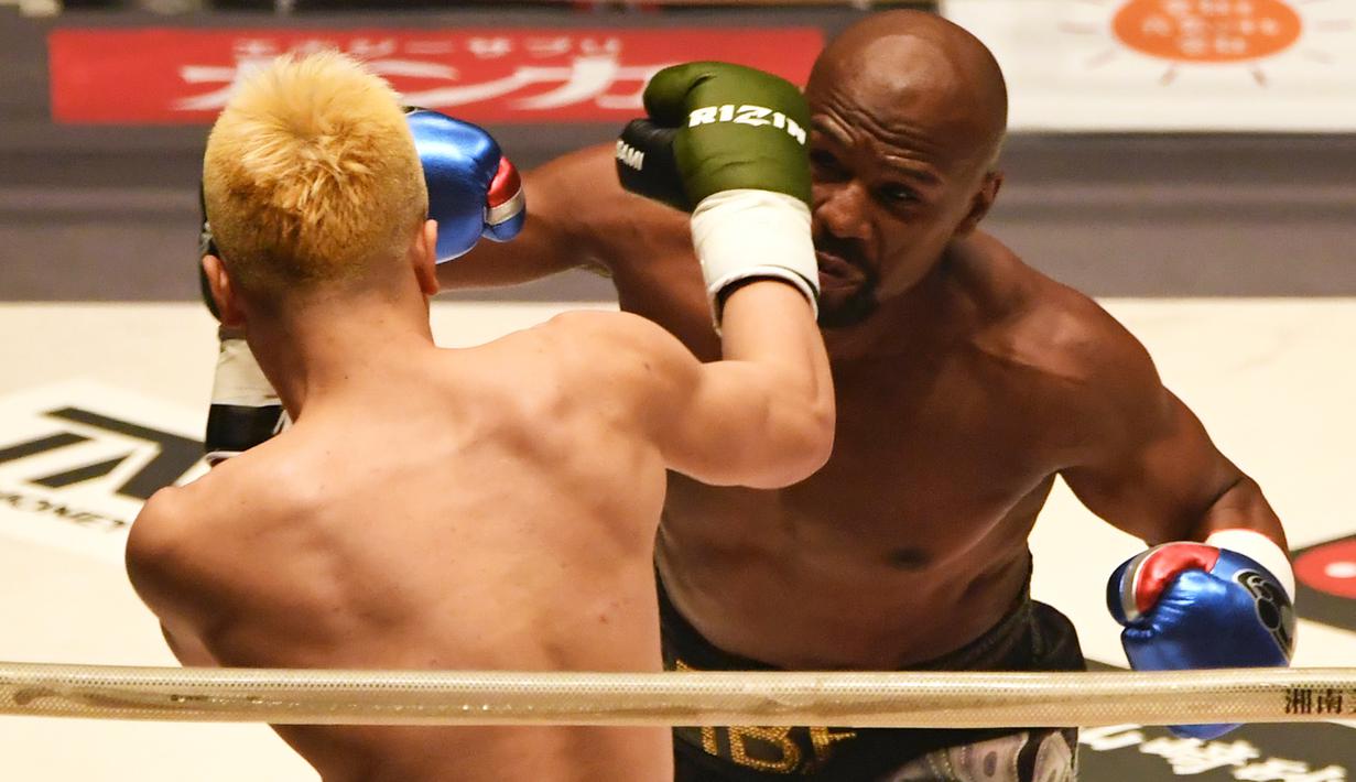 Petinju, Floyd Mayweather, beradu pukulan dengan kickboxer, Tenshin Nasukawa, pada laga eksebisi di Saitama Super Arena, Saitama, Senin (31/1). Tanding dengan aturan tinju, Mayweather menang TKO di ronde pertama. (AFP/Toshifumi Kitamura)