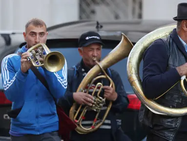 Aksi orkes tiup musisi Rumania untuk mendapat uang di jalanan Warsawa, Polandia pada 21 Oktober 2019. Orkes tiup yaitu sekelompok orang yang memperagakan musik dengan menggunakan instrumen musik tiup baik tiup logam maupun tiup kayu.  (AP Photo/Czarek Sokolowski)