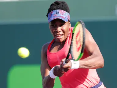 Petenis putri AS, Venus Williams mengembalikan bola ke arah juara bertahan Johanna Konta pada babak 16 besar Miami Terbuka di Candon Park, Senin (26/3). Venus membukukan kemenangan 5-7, 6-1, dan 6-2 dalam waktu 2 jam dan 19 menit. (AP Photo/Joe Skipper)