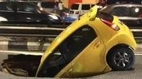 Daihatsu Sirion nyaris ditelan bumi ketika tengah melaju di Jalan Maharajalela menuju Jalan Loke Yew, Kuala Lumpur, Malaysia. (World of Buzz)