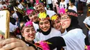 Sejumlah peserta berfoto sebelum mengikuti flashmob 1745 penari di kawasan Senayan, Jakarta, Minggu (21/8). Kegiatan bertajuk "Aku Indonesia-Bagimu Negeri Kami Menari" itu merupakan bagian dari perayaan HUT RI ke 71. (Liputan6.com/Fery Pradolo)