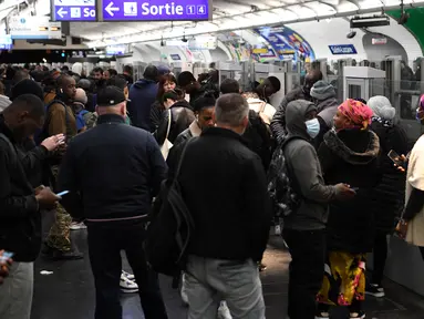 Komuter menunggu di peron stasiun Metro Saint-Lazare di Paris selama aksi pemogokan massal, Kamis (10/11/2022). Operator transportasi umum ibu kota Prancis, RATP, mengatakan hampir setiap jalur akan ditutup atau beroperasi hanya dengan layanan jam sibuk terbatas. (Bertrand GUAY / AFP)