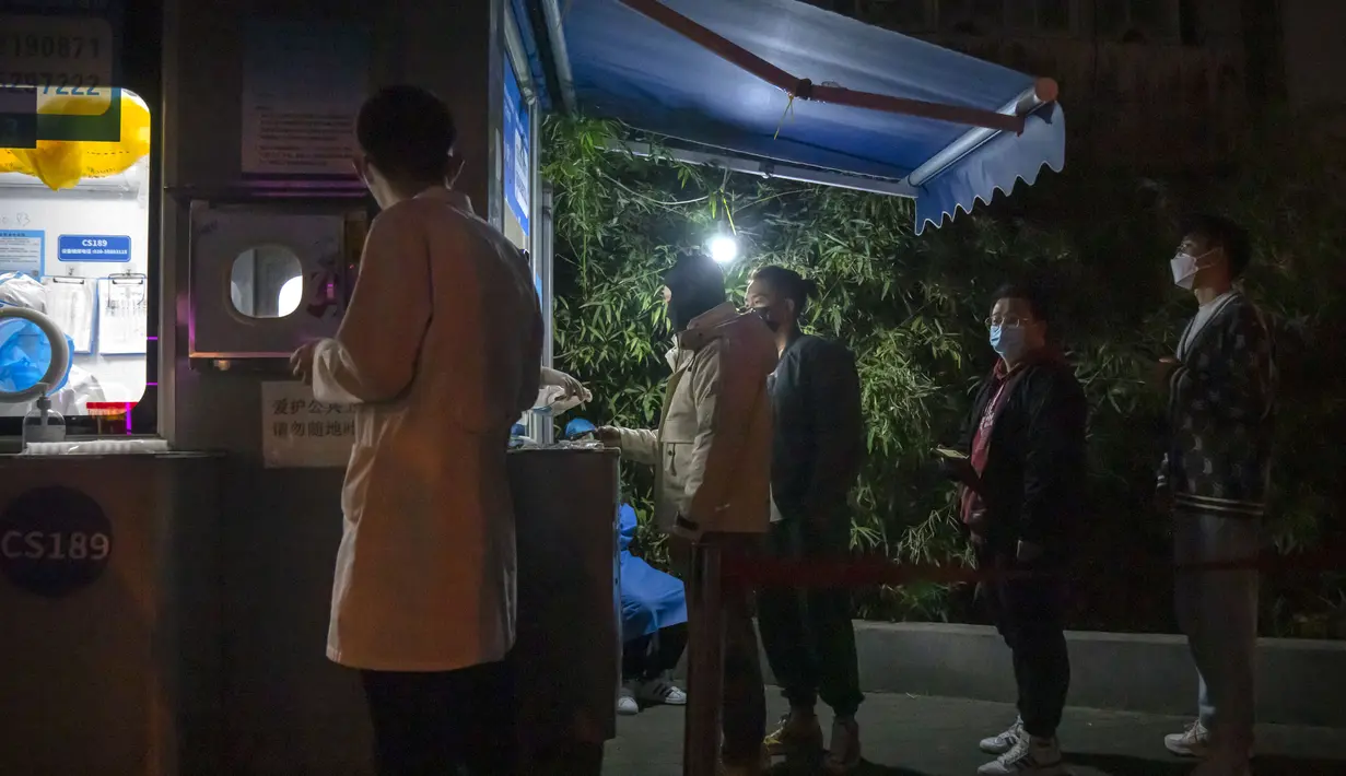 Orang-orang yang memakai masker mengantre untuk tes COVID-19 di tempat pengujian virus corona di Beijing, Rabu (2/11/2022). Para pekerja iPhone Apple Inc meninggalkan pabrik karena lokasinya berada dalam zona industri Kota Zhengzhou yang sedang diberlakukan lockdown setelah adanya 64 laporan kasus virus corona di kawasan tersebut. (AP Photo/Mark Schiefelbein)