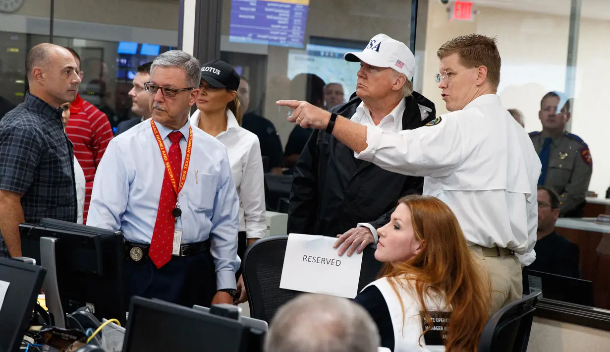 Presiden AS, Donald Trump bersama Ibu Negara Melania Trump mengunjungi pusat operasi darurat negara bagian Texas di Austin, Selasa (29/8). Trump mencoba menyemangati warganya lewat kunjungan ke Texas yang dihantam badai Harvey. (AP Photo/Evan Vucci)