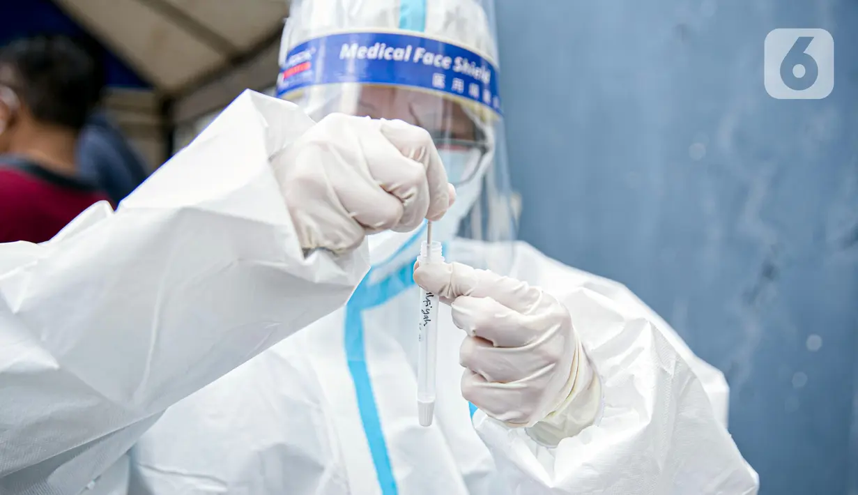 Petugas medis saat melakukan swab antigen terhadap pengungsi banjir di Universitas Borobudur, Cipinang Melayu, Jakarta, Minggu (21/2/2021). Pengungsi diwajibkan menjalani swab antigen untuk mencegah penyebaran COVID-19. (Liputan6.com/Faizal Fanani)