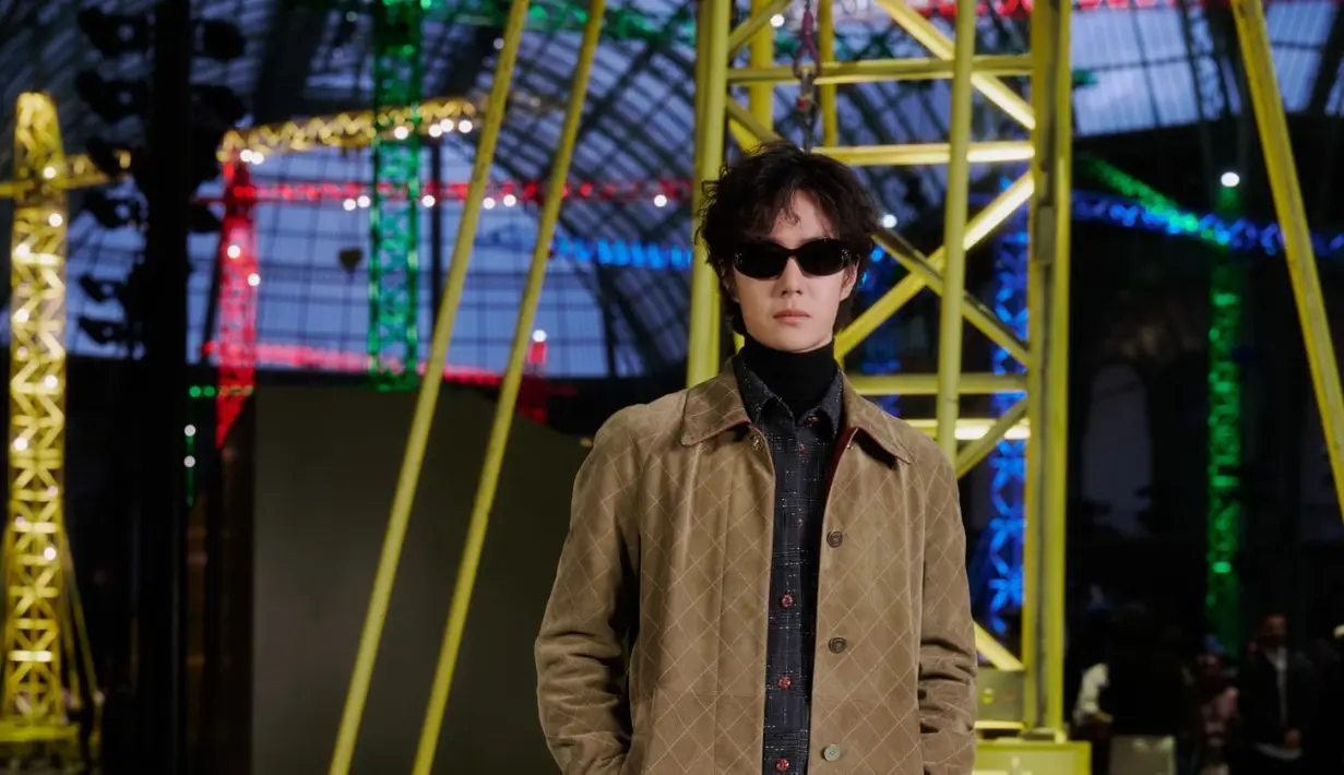 Aktor sekaligus idol Tiongkok Wang Yibo hadir dengan gaya maskulin yang sleek. Ia mengenakan long coat cokelat bermotif quilted yang dipadukan dengan turtleneck hitam serta kemeja bertekstur gelap. Celana hitam berpotongan lurus dan sepatu kulit memberikan kesan refined, sementara sunglasses hitam memperkuat aura cool yang understated.