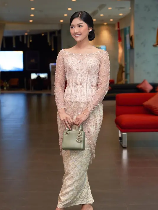 Manisnya penampilan Erina Gudono dibalut kebaya bernuansa nude. Kebaya ini memiliki detail leher yang lebar, dipadukan dengan kain wastra bernuansa keemasan yang serasi. [Foto: Instagram/erinagudono]