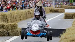 Salah satu peserta melompat saat mengendarai kendaraan unik buatannya dalam ajang Red Bull Soapbox Race di Sao Paulo, Brasil, Minggu (14/4). Balapan kotak sabun ini menggunakan kendaraan tanpa mesin yang dirakit peserta. (AP Photo/Nelson Antoine)