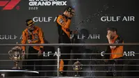 Juara F1 GP Bahrain 2025, Oscar Piastri (kiri), bersama rekan setimnya yang menempati podium ketiga, Lando Norris (tengah), dan team principal McLaren, Andrea Stella, merayakan keberhasilan tim di podium GP Bahrain, di Sirkuit Sakhir, Minggu (13/4/2025) malam WIB. (AP Photo/Altaf Qadri)