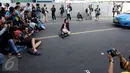Para fotografer melakukan pemotretan seorang model di Jalan MH Thamrin, Jakarta, Minggu (19/7/2015). Momen Jakarta sepi akibat banyak yang mudik, dimanfaatkan fotografer untuk memotret model. (Liputan6.com/Johan Tallo)