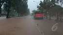 Sebuah angkutan umum mogok akibat nekat menerobos banjir yang menggenangi jalan Letjen Suprapto Cempaka Putih, Jakarta, Senin (9/2/2015). (Liputan6.com/Herman Zakharia)