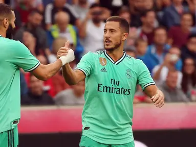 Gelandang Real Madrid, Eden Hazard berselebrasi dengan rekannya Karim Benzema setelah mencetak gol ke gawang Red Bull Salzburg pada laga persahabatan di Red Bull Arena, Austria (8/8/2019). Winger asal Belgia itu mencetak gol perdananya untuk klub barunya Real Madrid. (AFP Photo/Krugfoto)