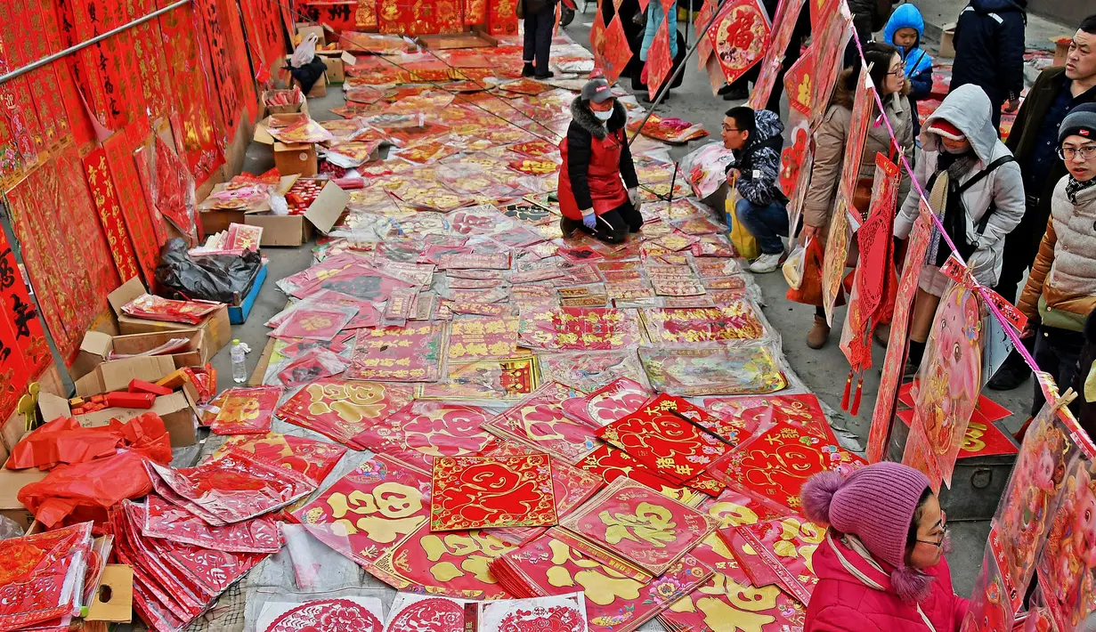 Warga berburu dekorasi untuk menyambut Tahun Baru Imlek di sebuah pasar di Yantai, Provinsi Shandong, China, Minggu (3/2). (Chinatopix via AP)