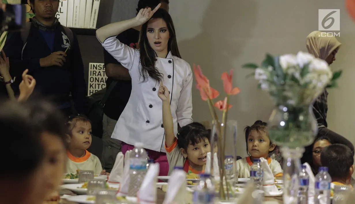 Artis Nia Ramadhani berbincang dengan anak paud setelah menyiapkan makan di kawasan Jakarta, Kamis (22/2). Bersama anggota Girls Squad, Nia membuat acara charity makan-makan dengan 20 anak-anak Paud Mekarsari, Jakarta Selatan. (Liputan6.com/Faizal Fanani)