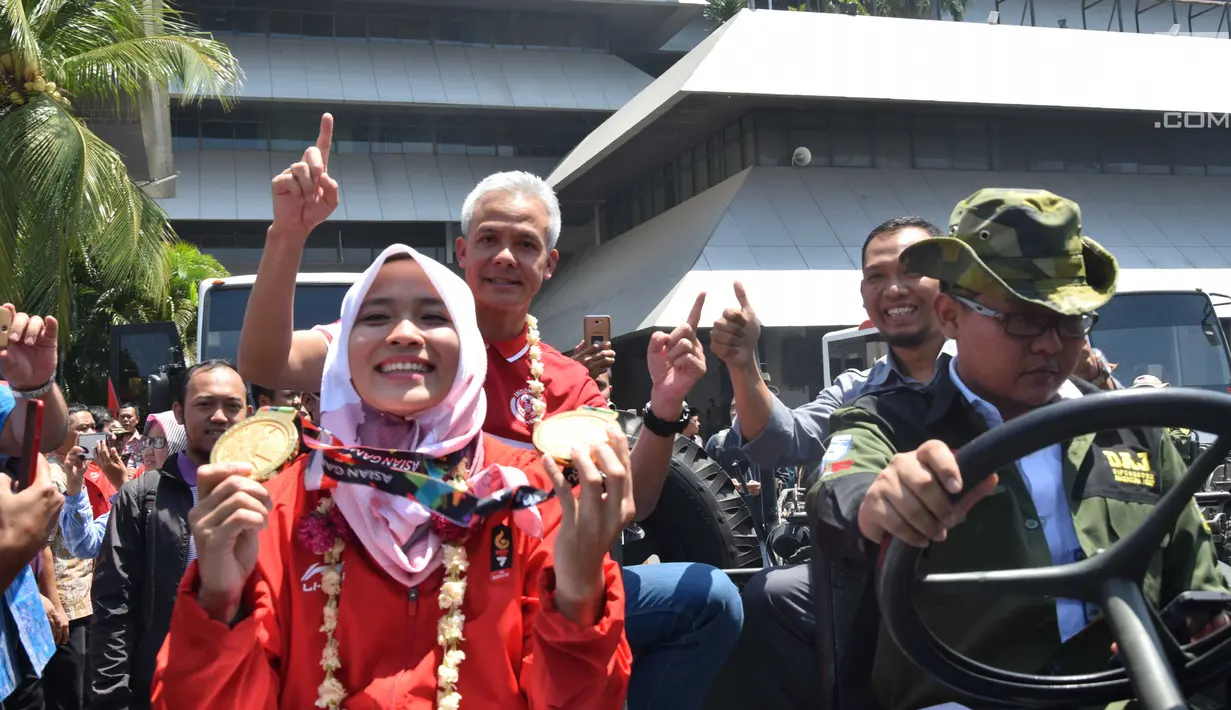 Peraih 2 medali emas dari cabor panjat tebing, Aries Susanti Rahayu menunjukkan medali saat hendak diarak keliling Kota Semarang, Selasa (4/9). Sejumlah atlet asal Jawa Tengah yang meraih medali Asian Games diarak keliling Semarang. (Liputan6.com/Gholib)