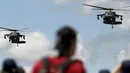 Sejumlah warga menyaksikan aksi manuver helikopter Blackhawk-Arpia di F-Air Colombia 2015 di F-Air Colombia 2015 di Rionegro, Kolombia (9/7/2015). Heli ini sering digunakan untuk misi-misi pasukan khusus. (REUTERS/Fredy Builes)