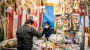 Seorang pria membeli dekorasi tahun baru di pekan raya akhir tahun di Distrik Nihonbashi, Tokyo, Jepang, 26 Desember 2022. Tak hanya menyuguhkan pemandangan indah dan makanan yang lezat, Jepang juga menjadi negara yang tepat untuk merayakan tahun baru. (Yuichi YAMAZAKI/AFP)