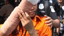 Istri tersangka pembunuhan wartawan Abdullah Fitri Setiawan alias Dufi yang tewas dalam drum, Sari menutupi wajahnya saat digelandang petugas di Polda Metro Jaya, Jakarta, Rabu (21/11). (Merdeka.com/Imam Buhori)