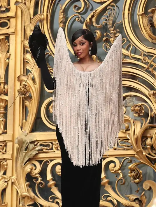 <p>Rapper asal Amerika Serikat itu tampil luar biasa dramatis dengan balutan gaun hitam yang dipadukan dengan aksesori fringe besar berbentuk segitiga terbalik di bagian dada dan bahu. [@cardifansbr].</p>