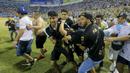Tragedi sepak bola yang melibatkan suporter kembali terjadi. Kali ini 12 orang dilaporkan meninggal dunia dalam sebuah insiden tragis di Stadion Monumental, Cuscatlan, San Salvador, El Salvador, Sabtu (21/5/2023) malam waktu setempat pada laga perempatfinal Divisi Utama El Salvador antara Alianza FC menghadapi Deportivo FAS. Para korban tewas akibat berdesakan saat menyerbu salah satu pintu masuk stadion. Akibat kejadian tersebut, laga pun terpaksa dihentikan setelah terjadi desak-desakan suporter yang meluber hingga ke dalam lapangan. (AP Photo/Milton Flores)
