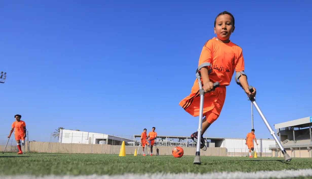 Anak-anak Palestina yang diamputasi berpartisipasi dalam sesi pelatihan sepak bola, yang diatur oleh Komite Palang Merah Internasional (ICRC) setelah pembatasan penyakit coronavirus (COVID-19) mereda, di Deir al-Balah di Jalur Gaza tengah (14/7/2020). (AFP/Mahmud Hams)