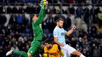 Kiper Hellas Verona, Nicolas Andrade (kiri) mengamankan bola dari kejaran pemain Lazio, Stefan de Vrij (kanan) pada lanjutan Serie A di di Olympic stadium, Roma, (19/2/2018). Lazio menang 2-0. (AFP/Alberto Pizzoli)