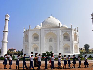 Dalam foto pada 25 November 2021 ini, anak-anak sekolah berjalan melewati replika Taj Mahal selama kunjungan mereka di Burhanpur, negara bagian Madhya Pradesh India. Pengusaha India Anand Prakash Chouksey membangun replika Taj Mahal untuk istrinya. (Uma Shankar MISHRA / AFP)