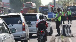 Aparat kepolisian Polres Cirebon Pantura mengatur lalu lintas kendaraan  ke arah Tol Cipali, Indramayu, Jakarta dan ke arah Jawa Tengah di Pos Palimanan Cirebon, Jawa Barat, Jumat (30/6). (Liputan6.com/Helmi Afandi)  