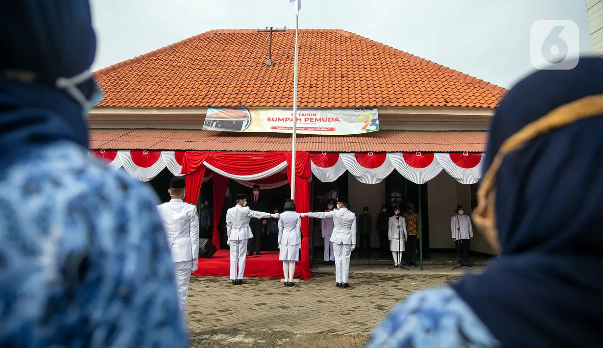 Anggota paskibra melakukan pengibaran bendera Merah Putih saat upacara di depan Museum Sumpah Pemuda, Jakarta, Kamis (28/10/2021). Upacara tersebut dilaksanakan untuk memperingati Hari Sumpah Pemuda ke-93. (Liputan6.com/Faizal Fanani)