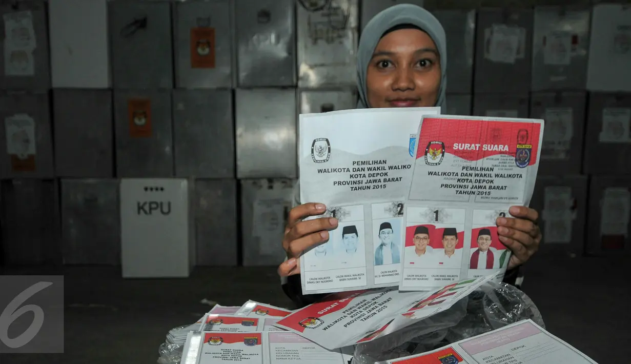 Anggota KPU Depok memperlihatkan surat suara yang rusak sebelum dimusnahkan di Gudang Logistik KPU Depok, Selasa (8/12). 1576 surat suara yang terdiri dari 398 rusak dan 1178 kelebihan tersebut di musnahkan dengan cara dibakar. (Liputan6.com/Yoppy Renato)