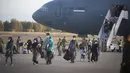 Pengungsi dari Afghanistan turun dari pesawat angkatan udara AS di Naval Station di Rota, Spanyol selatan, Selasa (31/8/2021).  Amerika Serikat menyelesaikan penarikannya dari Afghanistan Senin malam, mengakhiri perang terpanjang Amerika. (AP Photo/Marcos Moreno)