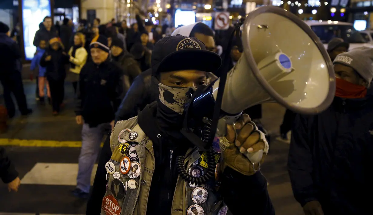 Pengunjuk rasa berorasi saat melakukan aksi protes di Chicago, Illinois, Rabu (25/11). Ketegangan rasial memanas setelah rilisnya video seorang polisi kulit putih menembak remaja kulit hitam, Laquan McDonald (17) pada Oktober 2014. (REUTERS/Andrew Nelles)