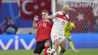 Striker Turki Baris Yilmaz dijaga ketat bek Austria Peter Lienhart pada laga 16 besar Euro 2024 (AP)
