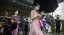 <p>Para penumpang bermasker dan membawa payung berjalan keluar dari stasiun kereta bawah tanah pada jam sibuk pagi hari pada hari hujan di Beijing, Rabu (29/6/2022). Pemerintah China mengurangi masa karantina wajib untuk pelancong yang merupakan pelonggaran pertama yang diterapkan negara itu kepada turis sejak Covid-19 merebak. (AP Photo/Mark Schiefelbein)</p>