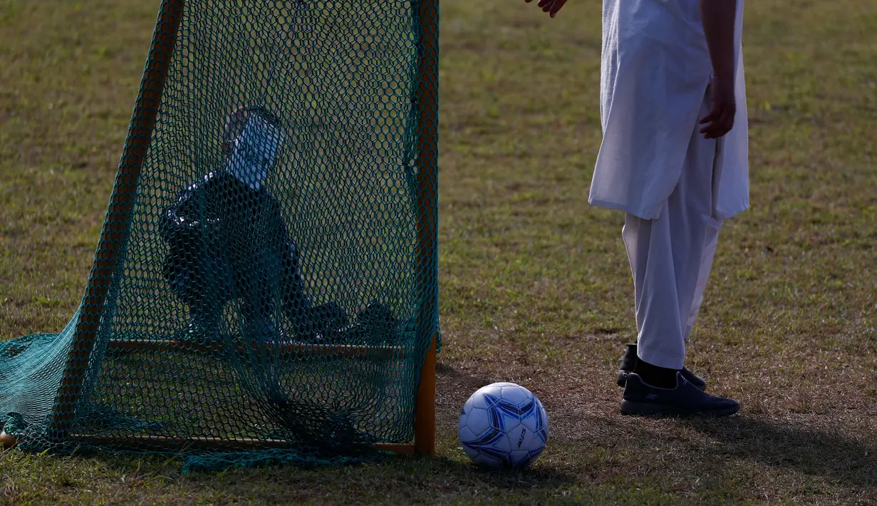 Pengungsi Afghanistan bermain sepak bola di taman bermain Institut Pengembangan Sumber Daya Manusia Nasional di Jincheon, Korea Selatan (13/10/2021). Sekitar 390 warga Afghanistan diterbangkan dari Kabul ke Korea Selatan. (AFP/Pool/Jeon Heon-kyun)
