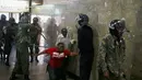 Para Polisi memukuli seorang demonstran di dalam sebuah gedung saat bentrokan di Nairobi, Kenya (16/5). Demonstran menuntut pembubaran otoritas pemilu karena adanya dugaan korupsi. (REUTERS/Goran (REUTERS/Goran Tomasevic)