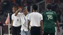 Pelatih Persebaya Surabaya, Aji Santoso (dua kiri), memberikan isyarat kepada salah satu asisten wasit bahwasannya bola umpan pemain Persebaya dibuang keluar oleh pemain Persija Jakarta. (Bola.com/Ikhwan Yanuar)