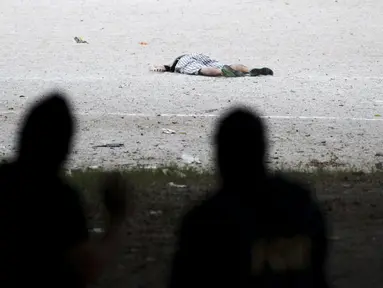 Polisi memeriksa salah satu korban pembunuhan d i sebuah lapangan sepak bola, Cuscatancingo, El Salvador, Minggu (2/8/2015).  Peristiwa ini menewaskan lima orang dan satu luka-luka setelah ditembak  anggota geng Mara Salvatrucha. (REUTERS/Jose Cabezas)