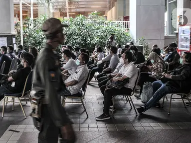 Jurnalis duduk antre untuk memverifikasi data sebelum mengikuti vaksinasi Covid-19 di Balai Kota, Jakarta, Senin (29/3/2021). Pemprov DKI Jakarta bekerja sama dengan Dewan Pers menggelar vaksinasi Covid-19 bagi 5.200 awak media. (merdeka.com/Iqbal S. Nugroho)