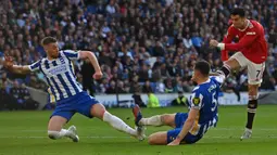 Pemain Manchester United Cristiano Ronaldo (kanan) melakukan tendangan yang diblokir pemain Brighton and Hove Albion pada pertandingan sepak bola Liga Inggris di American Express Community Stadium, Brighton, Inggris, 7 Mei 2022 . Manchester United kalah 0-4. (Glyn KIRK/AFP)
