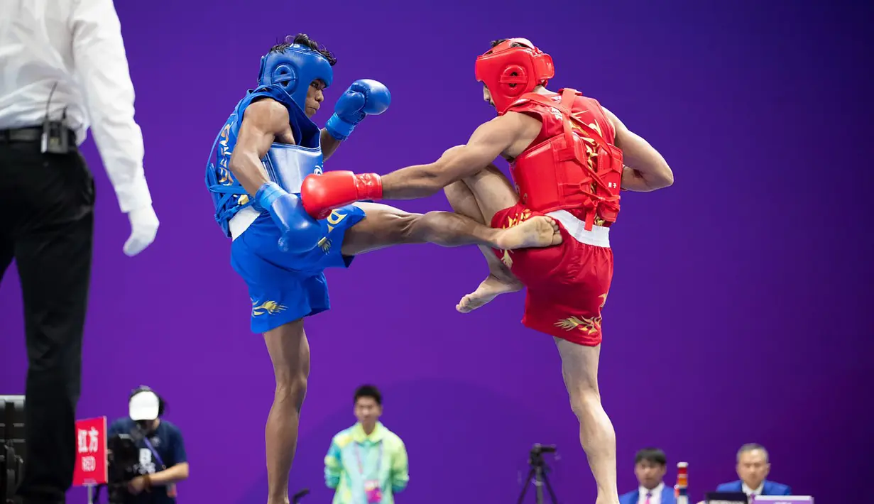 Atlet wushu Indonesia, Samuel Marbun (kiri) melepaskan tendangan ke arah lawannya, Afsin Shalimi Toupghara dari Iran pada laga final cabor wushu nomor sanda kelas 65kg putra Asian Games 2022 di Xiaoshan Guali Sports Centre, Hangzhou, China, Kamis (28/9/2023). (NOC Indonesia/Naif Al'as)